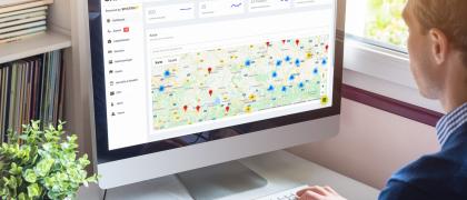 Man sitting on a computer. There is a map visible on the screen.